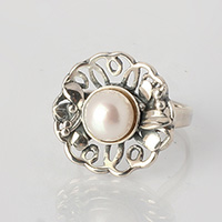Bague fleur en argent avec perle blanche.